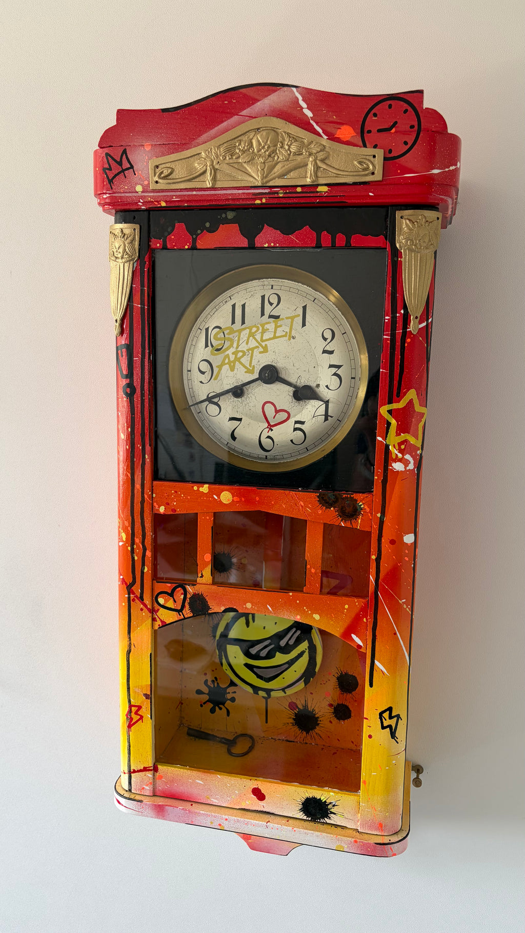 Pendule Street Art customisée — vue en angle montrant le relief du boîtier peint