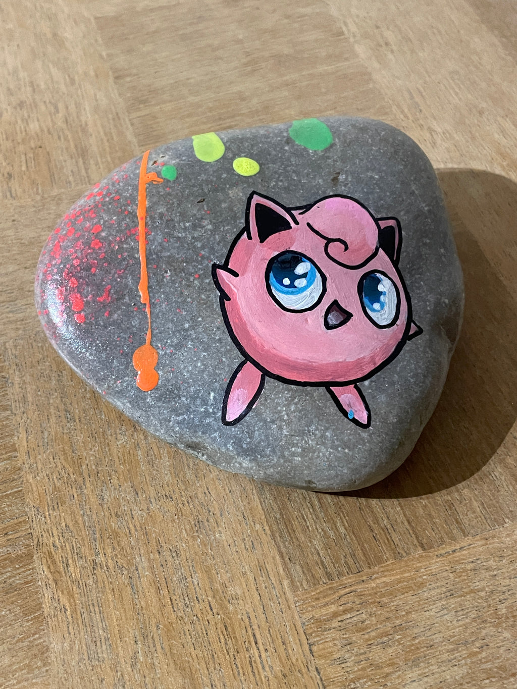 Galet peint pop art — éclaboussures de peinture et texture naturelle de la pierre