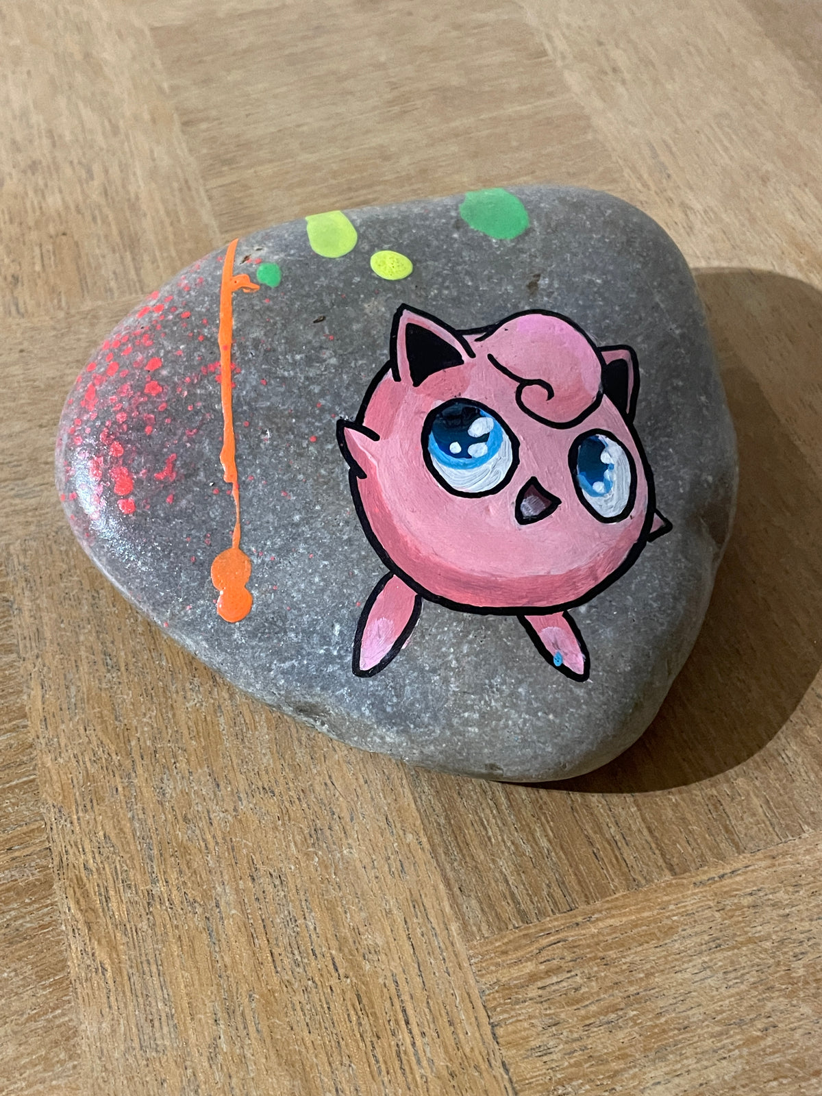 Galet peint pop art — éclaboussures de peinture et texture naturelle de la pierre
